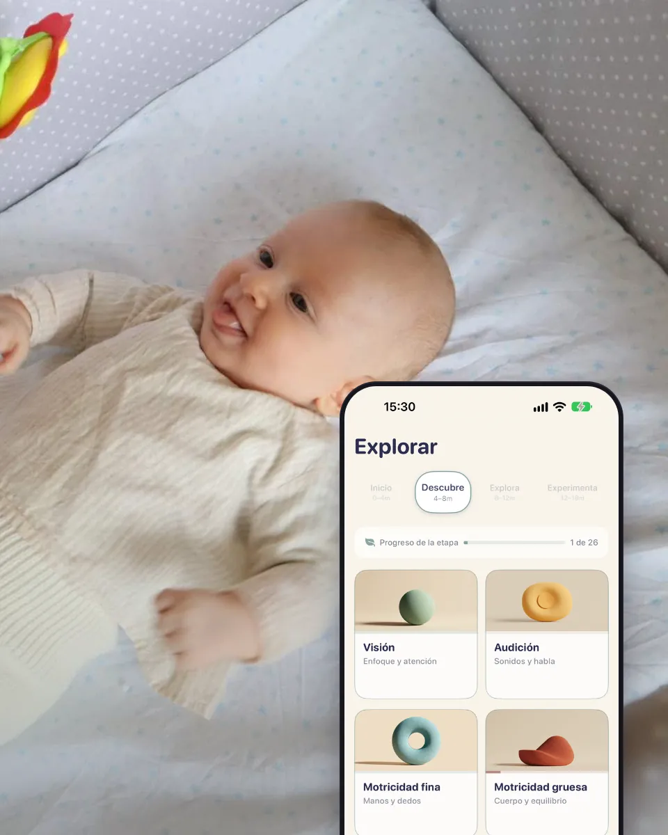 Un bebé en la cuna mira un sonajero, junto a la pantalla Explorar con las áreas de actividad.