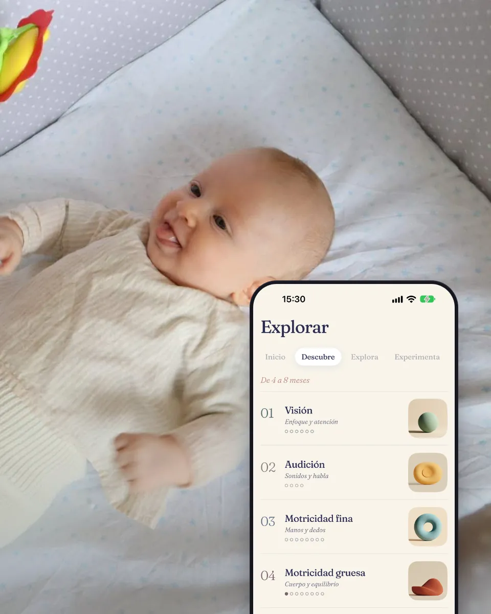 Un bebé en la cuna mira un sonajero, junto a la pantalla Explorar con las áreas de actividad.